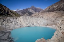 Scenery of blue lake surrounded by rocky mountains with steep slopes in vast valley in Nepal — Stock Photo