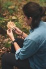 Зверху невідома жінка - міколог, що знімає бруд з гриба рамарії в лісі. — стокове фото
