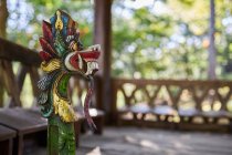 Sculpture of dragon with ornament on pedestal in aged construction made of bamboo in Bali Indonesia — Stock Photo