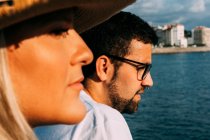 Seitenansicht einer Touristin gegen einen bärtigen Freund mit Brille, der das Meer betrachtet, während er in Saint Jean de Luz wegschaut — Stockfoto