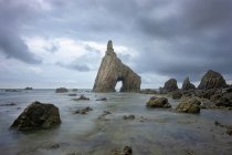 Spektakuläre Szenerie mit schäumenden Meereswellen, die raue Felsformationen verschiedener Formen am Strand von Campiecho in Asturien spülen — Stockfoto