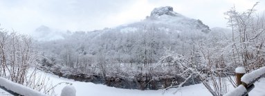Paisagem paisagística de encostas de montanha e vale coberto por neve branca sob céu nublado no Parque Natural Redes localizado em Ruta del Alba Astúrias Espanha — Fotografia de Stock