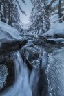 Довгий вплив швидкого водоспаду, який протікає через сніжну місцевість у національному парку Сьєрра - де - Гуадаррама. — стокове фото