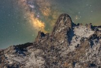 Magnifico paesaggio di aspre cime rocciose ricoperte di neve sotto il cielo stellato notturno con Via Lattea — Foto stock