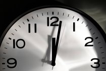 Horloge minimaliste ronde avec chiffres et flèches sur fond noir — Photo de stock