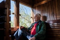 Homme attrayant et vieil homme voyageant dans une vieille voiture de train en bois regardant par la fenêtre — Photo de stock