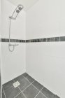 Interior del cuarto de baño con cabina de ducha vacía con paredes de baldosas blancas en apartamento - foto de stock