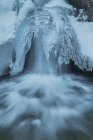 Longa exposição de cachoeira rápida que flui através de terreno nevado no Parque Nacional da Serra de Guadarrama — Fotografia de Stock