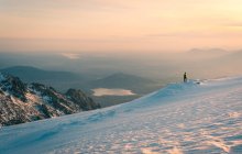Traveler standing on peak of snowy mountain and admiring spectacular landscape of highlands in Sierra de Guadarrama in Spain in sunlight — Stock Photo