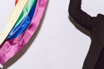Неузнаваемый бородатый мужчина играет и машет разноцветным флагом, символом гордости ЛГБТК — стоковое фото