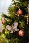 Branches of fir tree decorated with fairy lights and baubles for Christmas celebration — Stock Photo