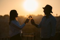 Side view of couple with beer looking at each other while spending time on balcony at sunset in Cappadocia, Turkey — Stock Photo