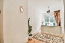 Innenraum des gemütlichen Schlafzimmers mit Topfpflanze und Bett in der Nähe des Fensters in zeitgenössischen Ferienhaus platziert — Stockfoto