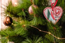 Tannenzweige mit Lichterketten und Christbaumkugeln zur Weihnachtsfeier geschmückt — Stockfoto