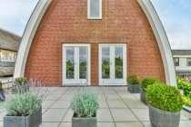 Progettazione creativa di esterni di edifici ad arco con tetto piastrellato contro le piante sotto il cielo nuvoloso in Provincia di Utrecht Olanda — Foto stock