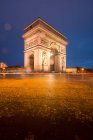 Vieille arche en pierre avec ornement et statues contre carré sous ciel bleu au crépuscule en hiver Paris France — Photo de stock