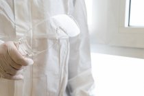Cultivé médecin masculin méconnaissable dans l'équipement de protection individuelle tenant sur lunettes à l'hôpital — Photo de stock