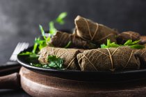 From above of palatable sarma with parsley and fork on dark background — Stock Photo