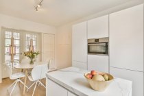 Intérieur d'une cuisine spacieuse avec un mobilier élégant et lumineux dans des appartements modernes de luxe en journée — Photo de stock