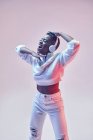 Енергетична етнічна жінка в бездротових навушниках і модний одяг танцює хіп-хоп з відкритим ротом — стокове фото