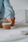Неузнаваемая женщина в кольце с чашкой вкусного кофе с молочной пеной в спальне — стоковое фото