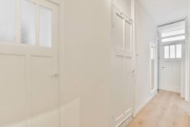Interno di corridoio con porte e pareti chiare in stile minimalista in appartamento moderno — Foto stock