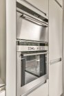 Вбудована мікрохвильова піч з панеллю управління проти холодильника на сучасній кухні вдома — стокове фото