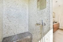 Salle de bain contemporaine intérieur avec murs en mosaïque dans la salle de douche contre armoire avec lavabos dans la maison — Photo de stock