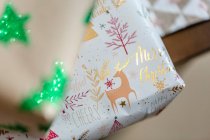 Colección de regalos de Navidad envueltos en papel y cintas colocadas cerca de ramas de abeto - foto de stock