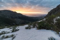 Paisaje de crestas escarpadas ásperas bajo el cielo nublado de la puesta del sol en la noche de invierno en las tierras altas - foto de stock