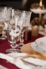 Хрустальные бокалы со столовыми приборами возле тарелок на праздничном столе подаются на рождественский ужин — стоковое фото