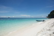 Praia de areia branca molhada lavada pelo mar infinito transparente claro sob o céu azul na Malásia — Fotografia de Stock