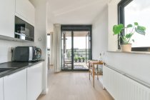 Moderno interno cucina con armadi e macchina per il caffè contro spazzatura può a casa alla luce del sole — Foto stock