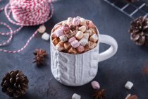From above of ceramic mug with sweet cocoa with marshmallows near fir cones and rope for tying Xmas gifts — Stock Photo