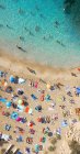 Drone view of travelers on sandy coast of Ibiza against rippled sea in sunlight in Spain — Stock Photo