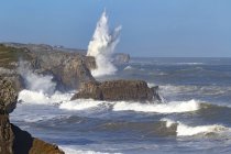 Espectacular paisaje con olas de mar espumosas lavando formaciones rocosas rugosas de diversas formas en la playa campiecho de Asturias España - foto de stock