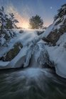 Long exposure of fast waterfall flowing through snowy terrain in Sierra de Guadarrama National Park — Stock Photo