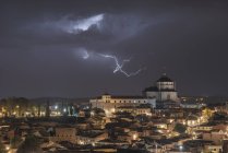 Stadtbild von Toledo mit hohem gealtertem Turm unter bewölktem Himmel mit Blitz während eines Gewitters in der Nacht — Stockfoto