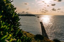 Pintoresca vista del muelle en el océano ondulado con agua brillante entre los montes al atardecer en Saint Jean de Luz - foto de stock