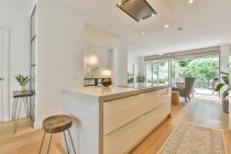 Interior da cozinha moderna com mobiliário branco e eletrodomésticos em novo apartamento espaçoso — Fotografia de Stock