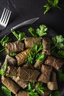 From above of palatable sarma with parsley and fork on dark background — Stock Photo