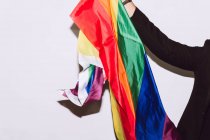 Cortar irreconhecível barbudo masculino jogando e acenando multicolorido bandeira símbolo do orgulho LGBTQ — Fotografia de Stock