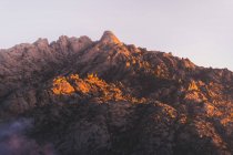 Szenische Ansicht von Pedriza mit schroffen Berg und Schatten unter hellem Himmel in der sonnigen Morgendämmerung in Spanien — Stockfoto