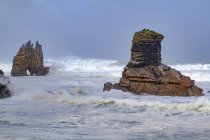 Cenário espetacular com ondas marinhas espumosas lavando formações rochosas ásperas de várias formas em Portizuelo, Astúrias Espanha — Fotografia de Stock