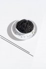 Зверху керамічна миска з смачною спагетті з чорним кальмаром з паличками на білому тлі — стокове фото
