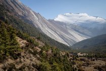 Hautes pentes escarpées de montagnes couvertes de neige situées dans la chaîne de vallée de l'Himalaya sous un ciel coloré au Népal — Photo de stock