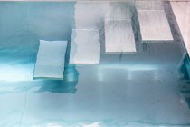 Зверху сходи в басейні з прозорою блакитною водою в денне світло — стокове фото