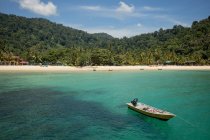 Scenery of clear transparent seawater with boats on sandy beach and exotic rainforest in Malaysia — Stock Photo