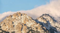 Pendiente de montaña cubierta de nieve y nubes en frío día de invierno en el Parque Nacional Sierra de Guadarrama - foto de stock