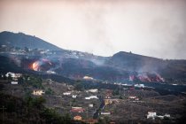 Горячая лава и магма вытекают из кратера, разрушая городские дома. Извержение вулкана Кумбре-Вьеха на Канарских островах, Испания, 2021 год — стоковое фото